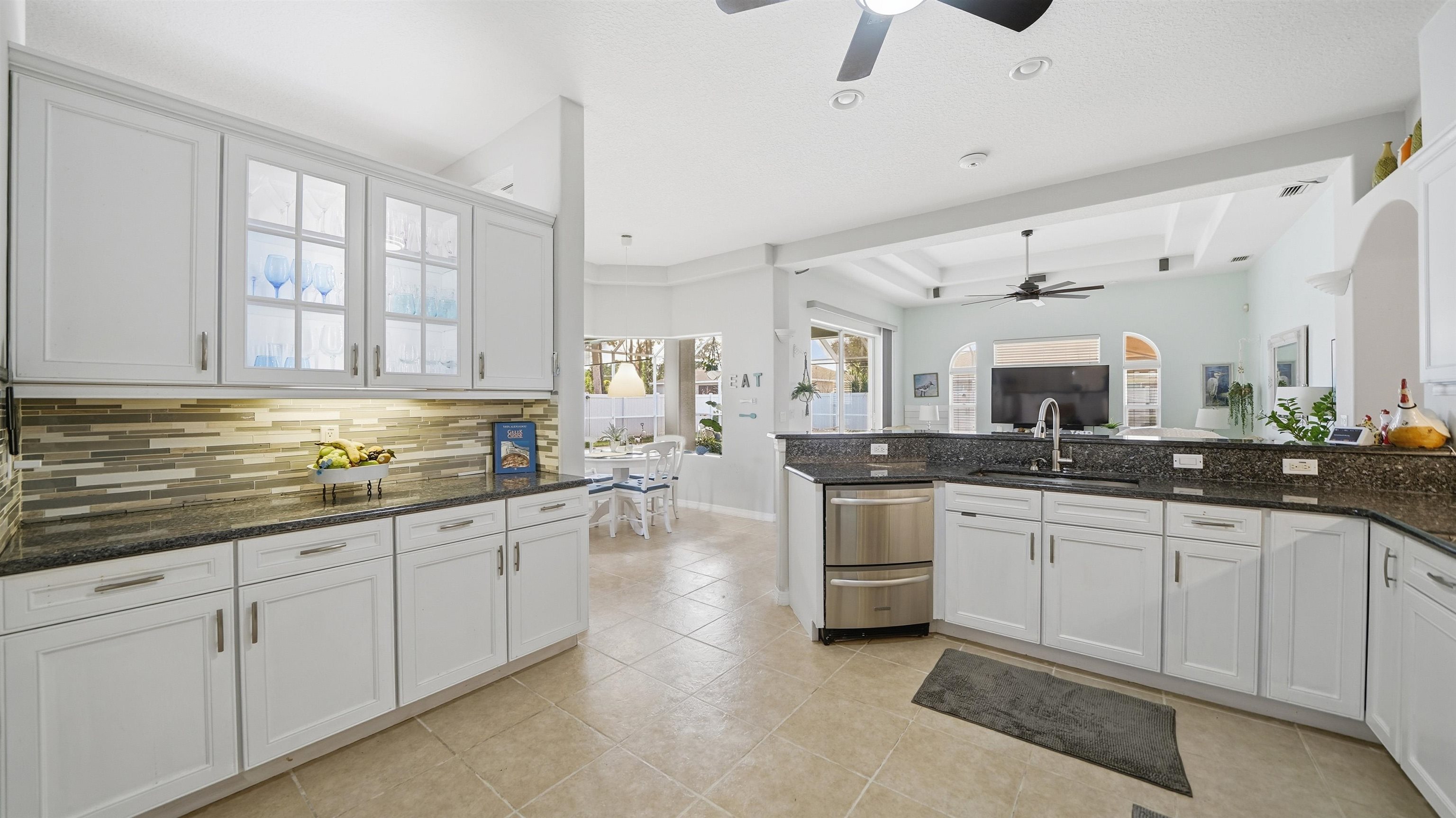22 Flanders Lane Palm Coast, FL 32137 - Photo 8 of 70 a large white kitchen with stainless steel appliances granite countertop a sink and cabinets with wooden floor