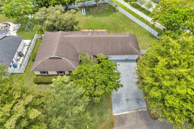 an aerial view of a house with swimming pool and garden