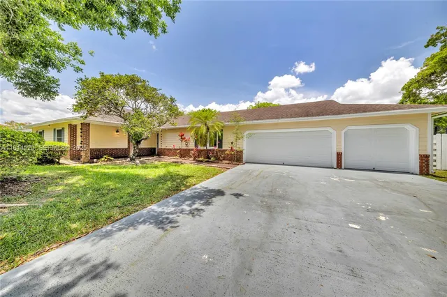 a front view of a house with a yard and a garage