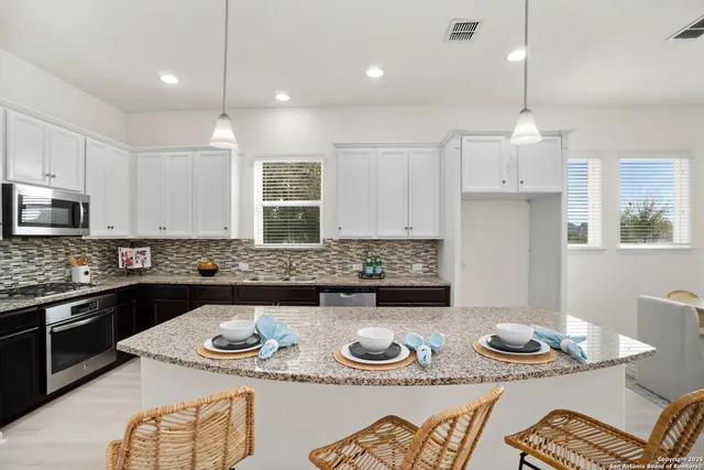 a kitchen with stainless steel appliances granite countertop a sink and a stove