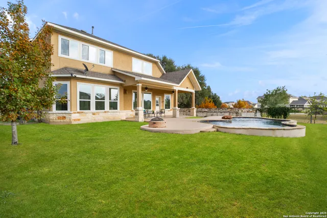a front view of a building with garden and trees