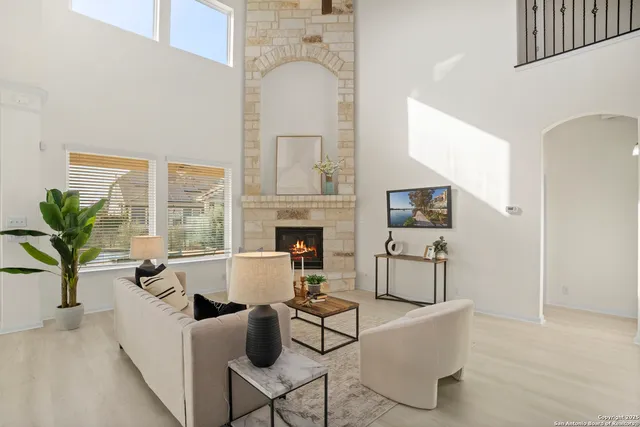 a living room with furniture a fireplace and potted plants