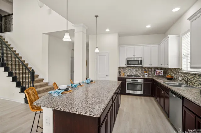 a kitchen with stainless steel appliances granite countertop a sink stove and refrigerator
