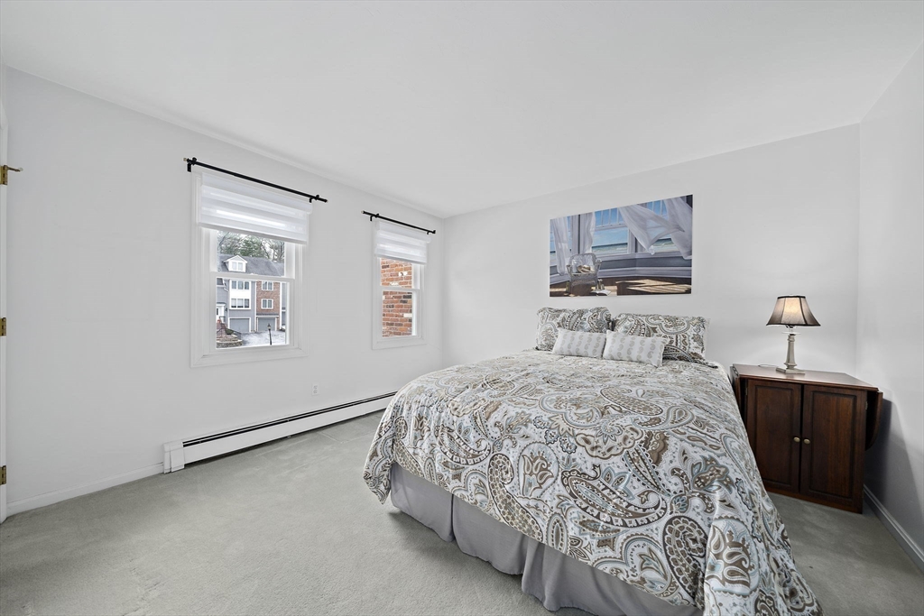 84 Walpole Street, Unit 3L Canton, MA 02021 - Photo 19 of 29 a bedroom with a bed and a chandelier