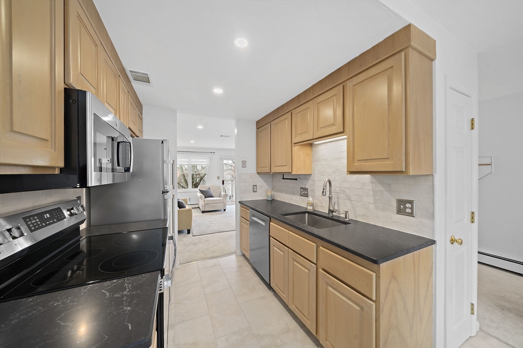 84 Walpole Street, Unit 3L Canton, MA 02021 - Photo 4 of 29 a kitchen with stainless steel appliances granite countertop a sink a stove and a refrigerator