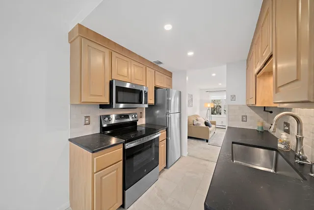 a kitchen with stainless steel appliances a stove a sink a microwave and cabinets