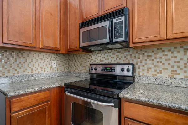 a kitchen with wooden cabinets and a stove top oven