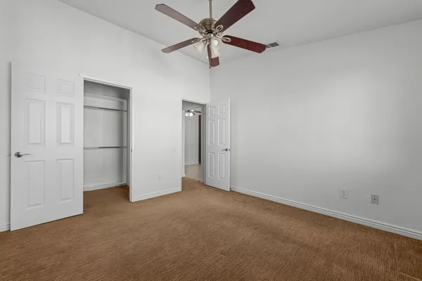 an empty room with closet and windows