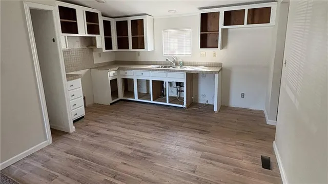 a view of kitchen with stainless steel appliances granite countertop a sink and wooden floor