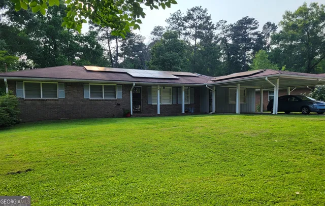 a view of a brick house with a large window and large trees