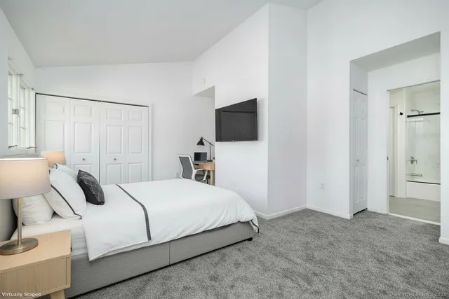 a bedroom with a bed and a flat screen tv