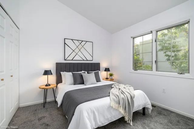 a bed sitting in a bedroom next to a window