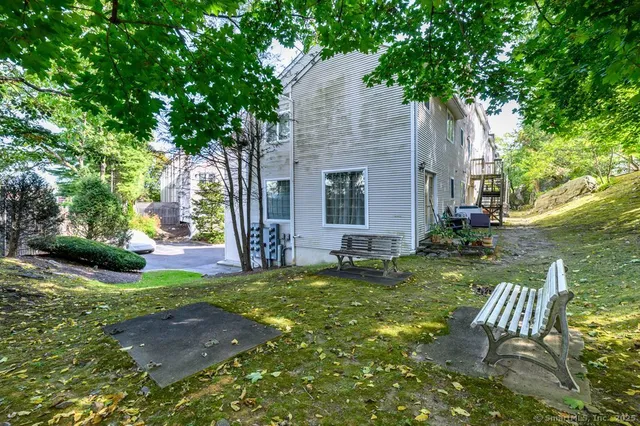 a view of a chair and table in backyard of the house