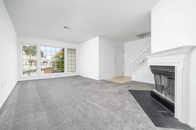 a view of an empty room with a fireplace and a window