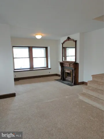 an empty room with a fireplace and windows