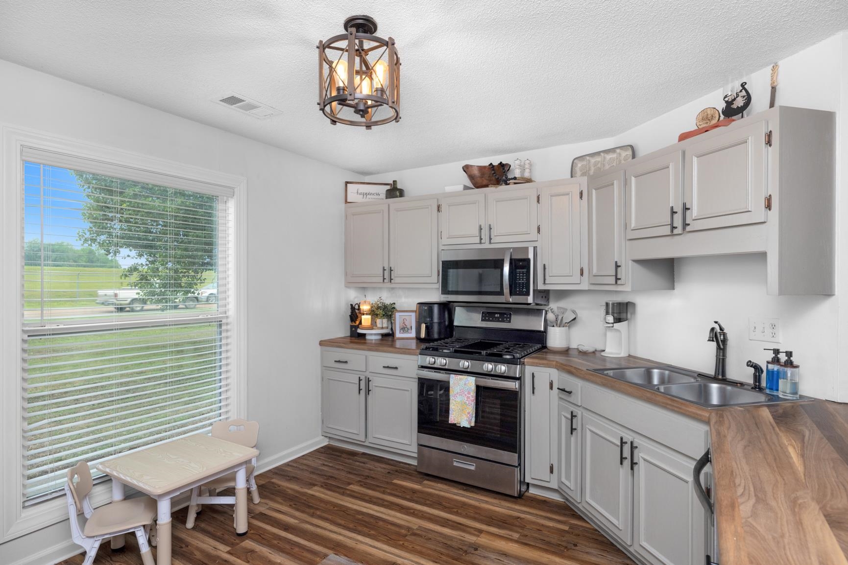 586 Beaver Road Munford, TN 38058 - Photo 8 of 21 Kitchen featuring shaker-style cabinetry, stainless steel appliances, wood-finish countertops, and wood-finish flooring