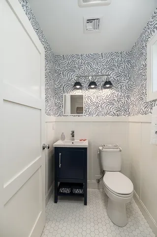 a bathroom with a toilet a sink and mirror