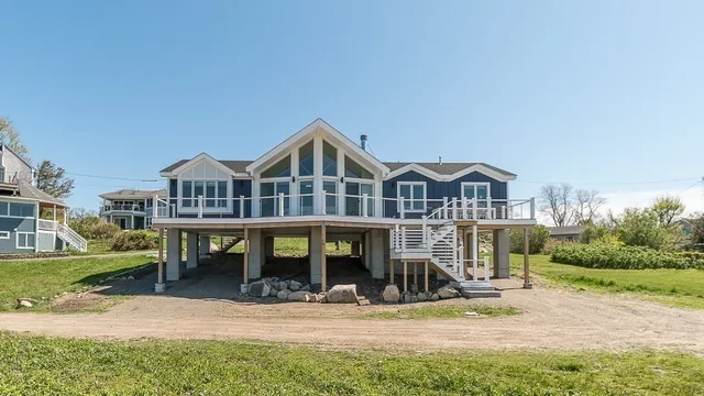 a view of a big house with large windows and a yard