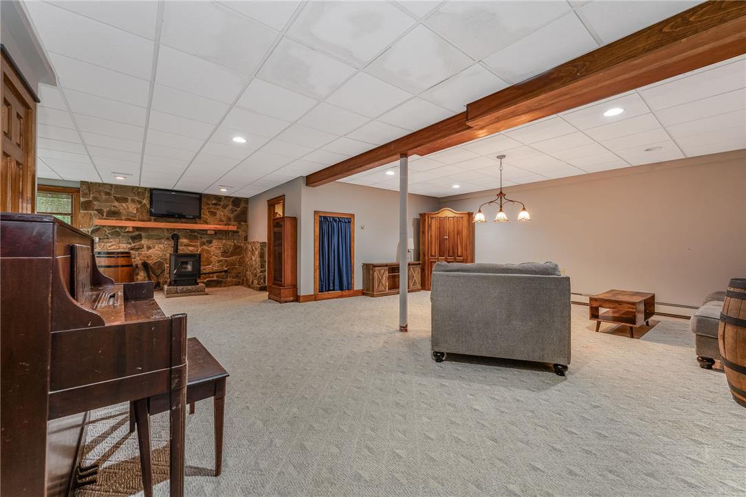 465 Raubsville Road Easton, PA 18042 - Photo 50 of 60 Warm and inviting, this generously proportioned lower-level retreat boasts a cozy wood-burning stove set against a rustic stone accent wall.