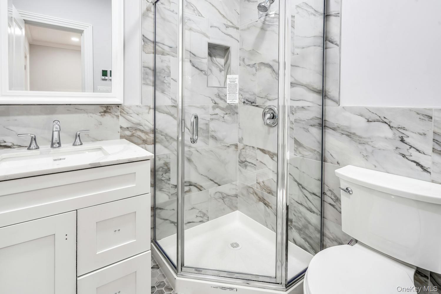 539 Split Rock Road Syosset, NY 11791 - Photo 17 of 40 Full bathroom featuring tile walls, vanity, toilet, and a marble finish shower