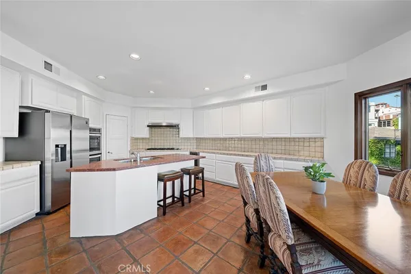 a kitchen with stainless steel appliances granite countertop a sink and a refrigerator
