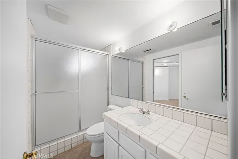 a bathroom with a granite countertop sink mirror and shower
