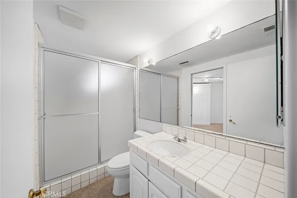 a bathroom with a granite countertop sink mirror and shower