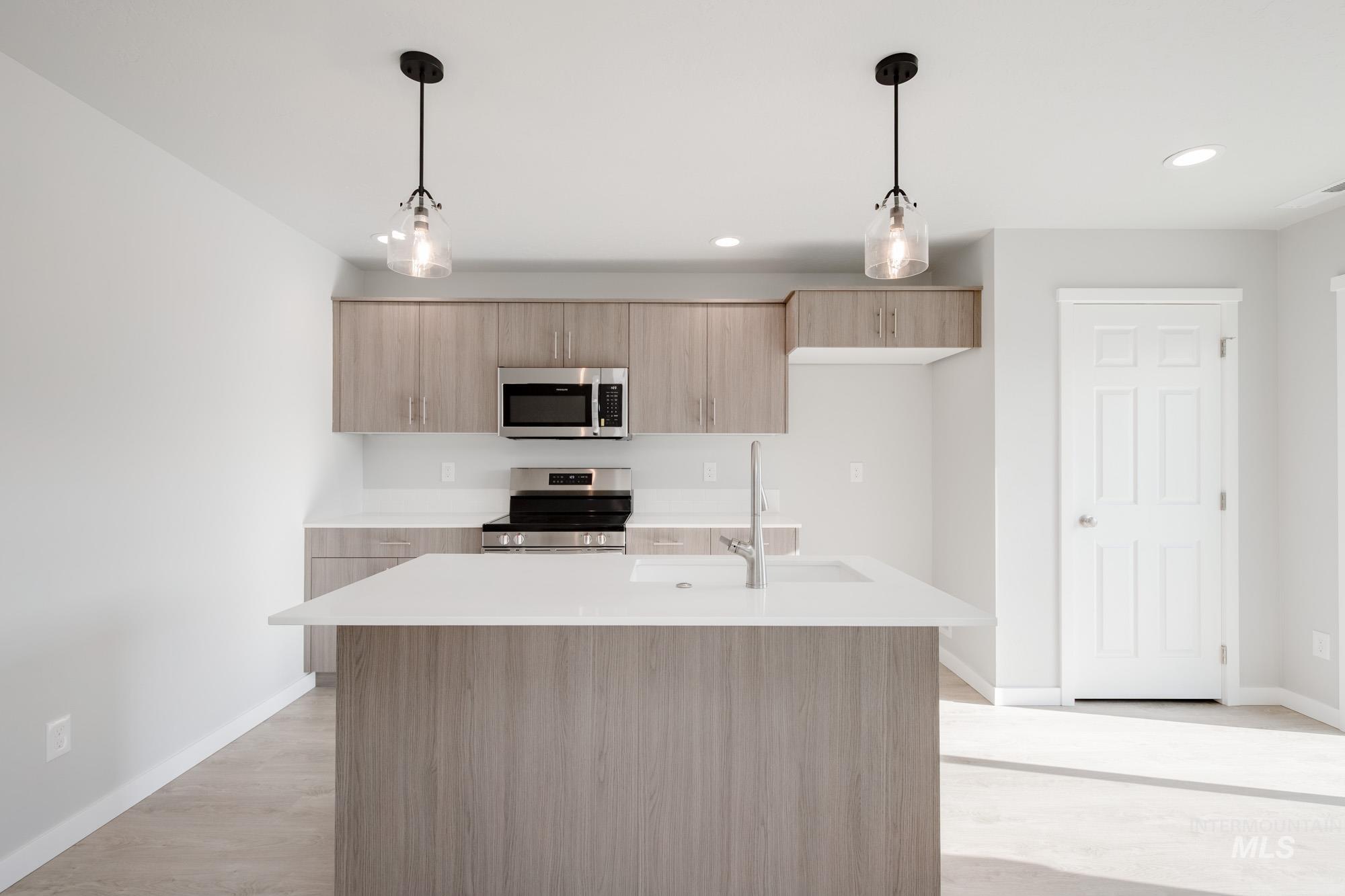 229 Moose Street Horseshoe Bend, ID 83629 - Photo 3 of 27 Kitchen featuring pendant lighting, stainless steel appliances, a center island with sink, modern cabinets, and light brown cabinets