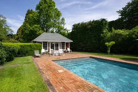 a front view of a house with swimming pool having outdoor seating