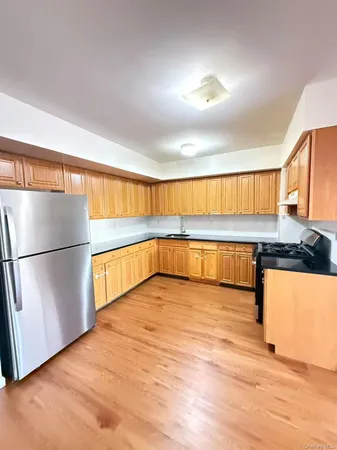 a view of a kitchen with stainless steel appliances granite countertop a refrigerator and a ocean view