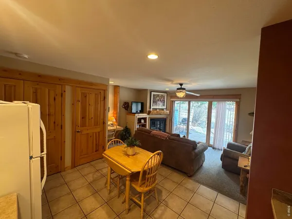 a living room with furniture a large window and stainless steel appliances