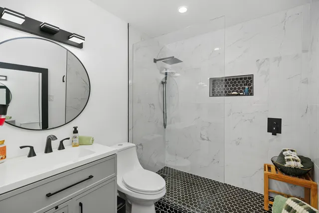 a bathroom with a toilet a sink and mirror