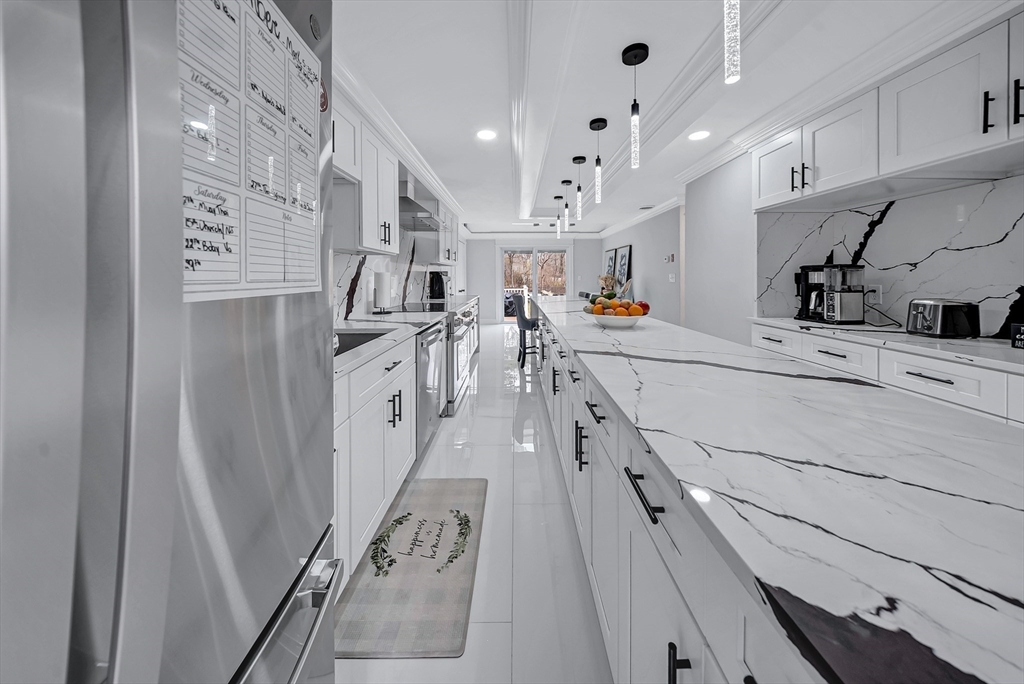 3 Stoddard Street Upton, MA 01568 - Photo 8 of 42 a kitchen with stainless steel appliances kitchen island wooden floors and refrigerator