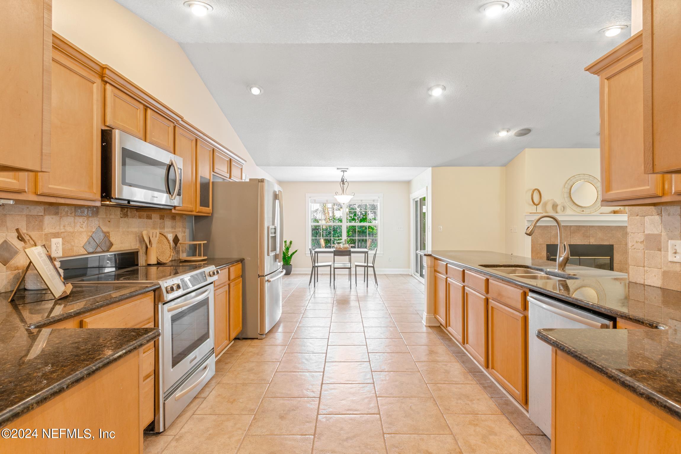 205 Shirley's Way St. Augustine, FL 32086 - Photo 11 of 57 a large kitchen with stainless steel appliances granite countertop a stove a sink and a microwave