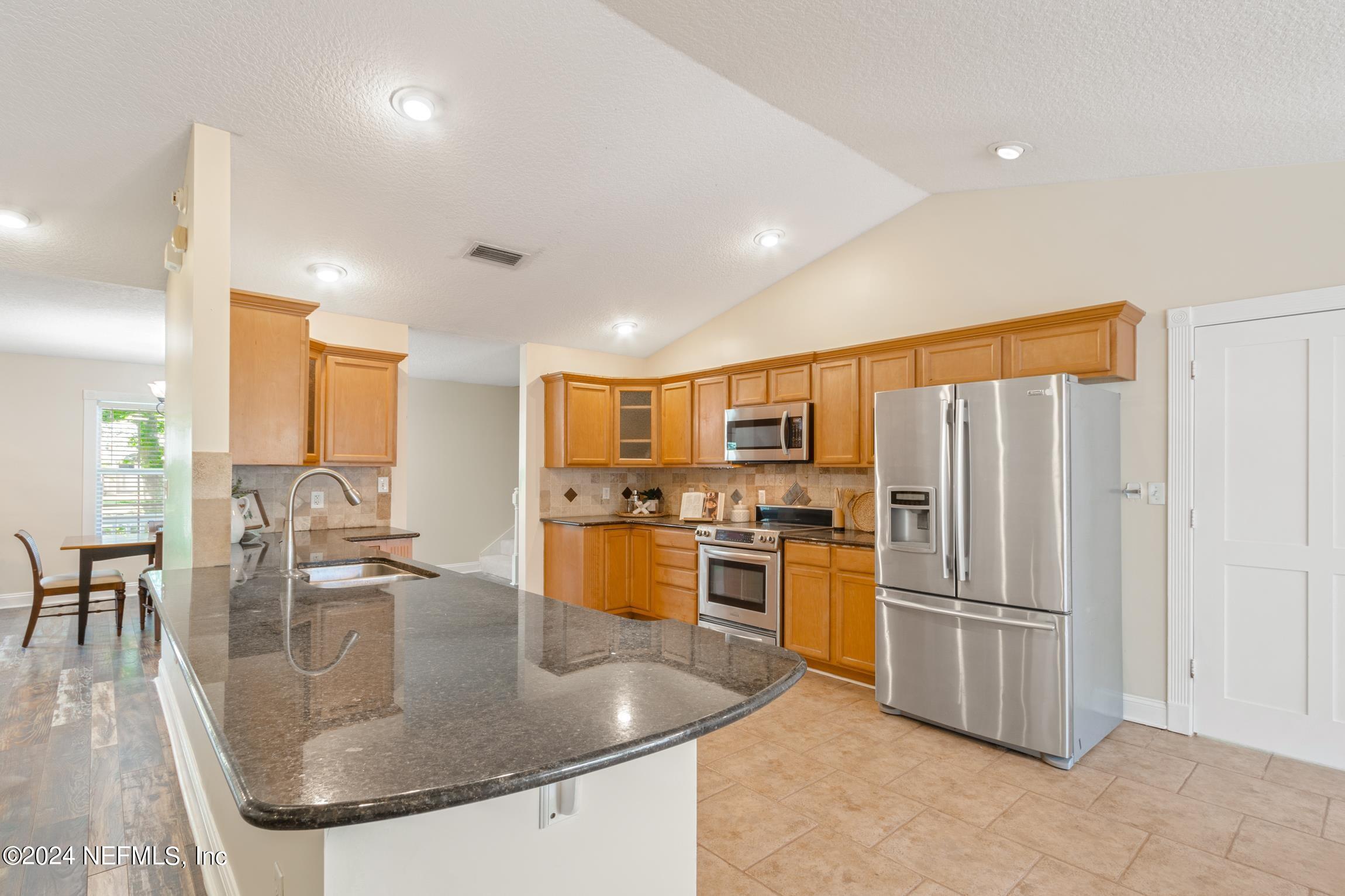 205 Shirley's Way St. Augustine, FL 32086 - Photo 7 of 57 a kitchen with stainless steel appliances granite countertop a sink a stove and a refrigerator