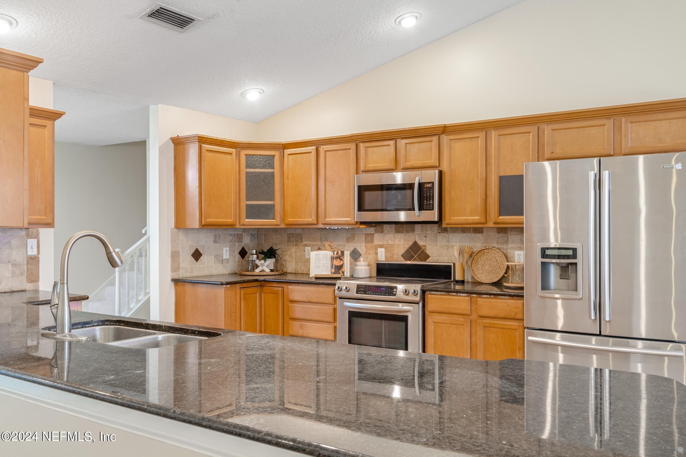 205 Shirley's Way St. Augustine, FL 32086 - Photo 8 of 57 a kitchen with stainless steel appliances granite countertop a stove top oven a sink a dining table and chairs
