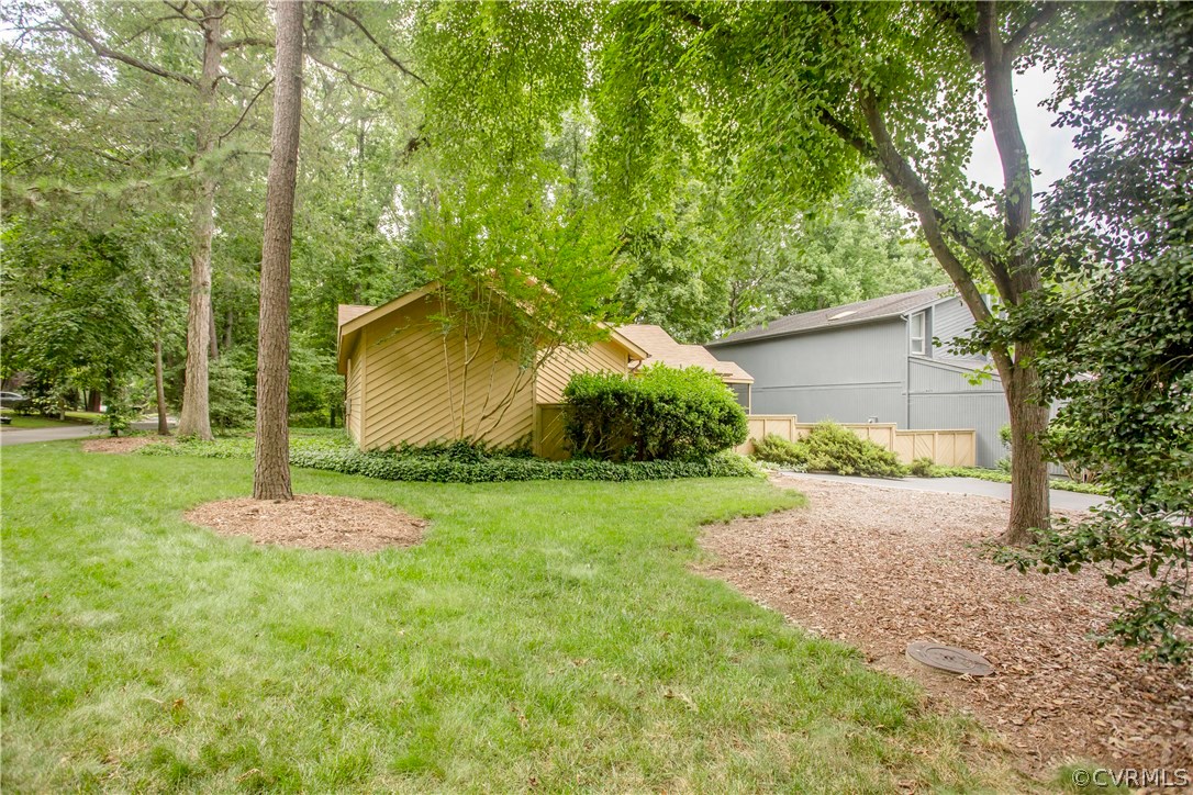 14338 Regatta Pointe Road Midlothian, VA 23112 - Photo 39 of 40 a backyard of a house with plants and large trees