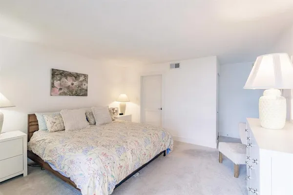 a bedroom with a large bed and a night stand