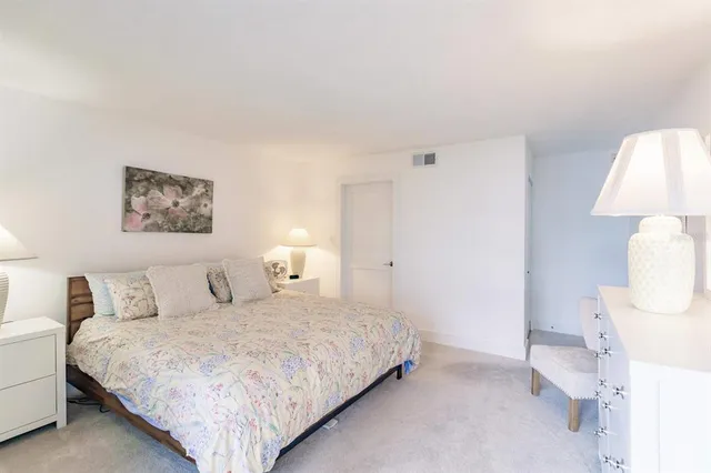 a bedroom with a large bed and a night stand