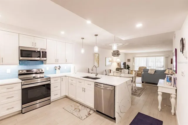 a kitchen with white cabinets and stainless steel appliances