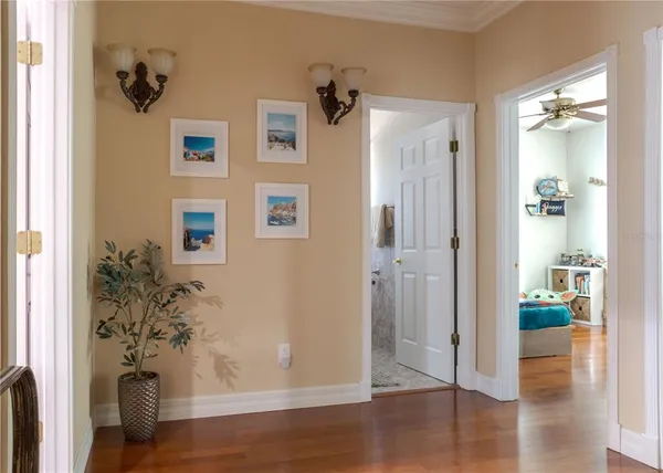 a view of a hallway with wooden floor and a living room
