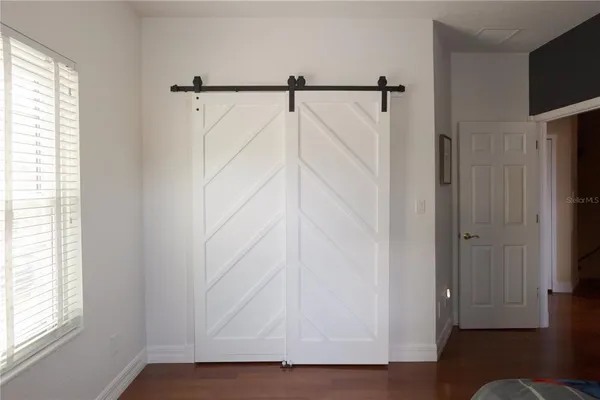 a view of walk in closet with window and wooden floor