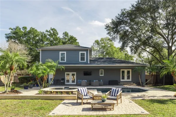 a front view of a house with swimming pool and furniture