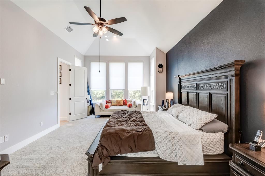 126 LITTLE Strm Cove Austin, TX 78737 - Photo 25 of 40 Elegant bedroom with vaulted ceilings, featuring a rich wood bed frame and abundant natural light.