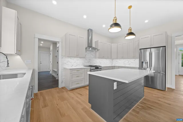 a kitchen with stainless steel appliances granite countertop a sink a stove and a wooden floors