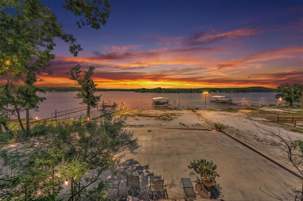 566 Selma Park Road Bowie, TX 76230 - Photo 36 of 40 Waterfront property featuring multiple boat slips, a concrete patio, and mature trees