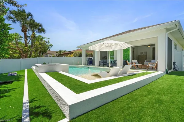 a view of an house with swimming pool and chairs