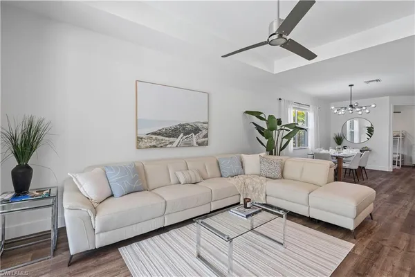 a kitchen with a table chairs refrigerator and wooden floor