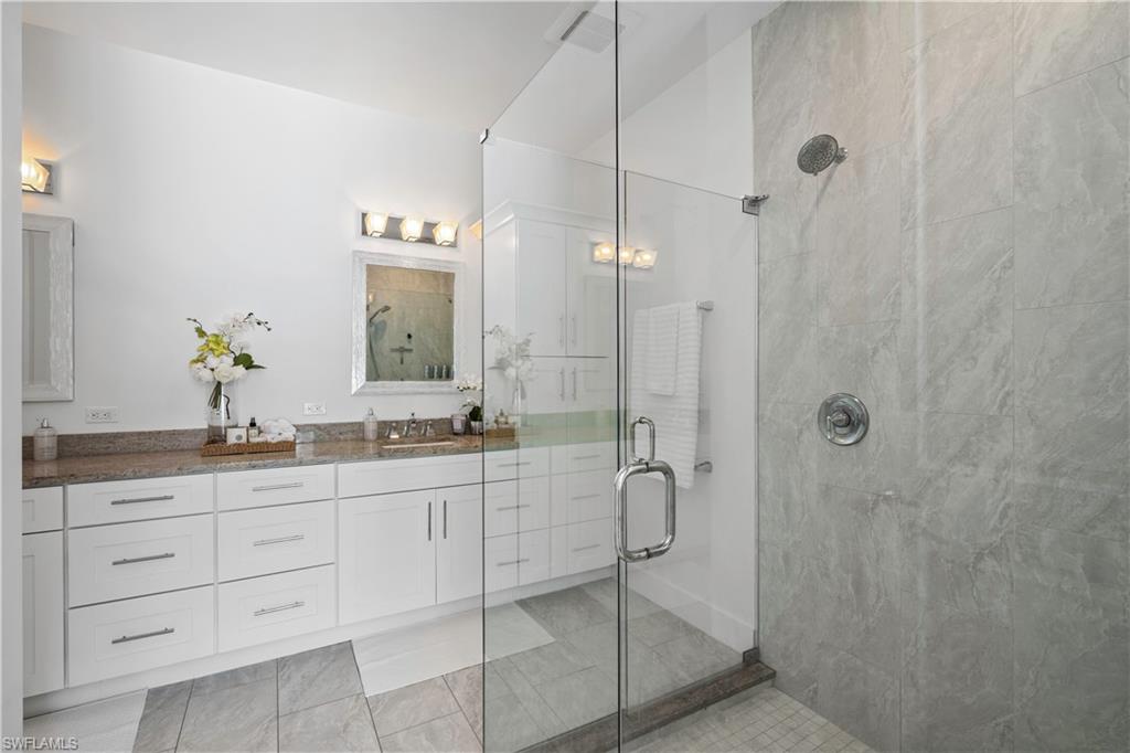 1100 Steeves Avenue Naples, FL 34104 - Photo 33 of 38 a bathroom with a granite countertop sink a mirror and shower