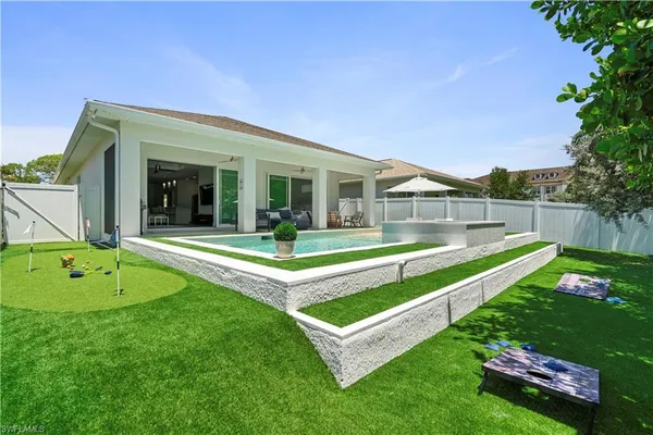 a view of house with swimming pool and yard